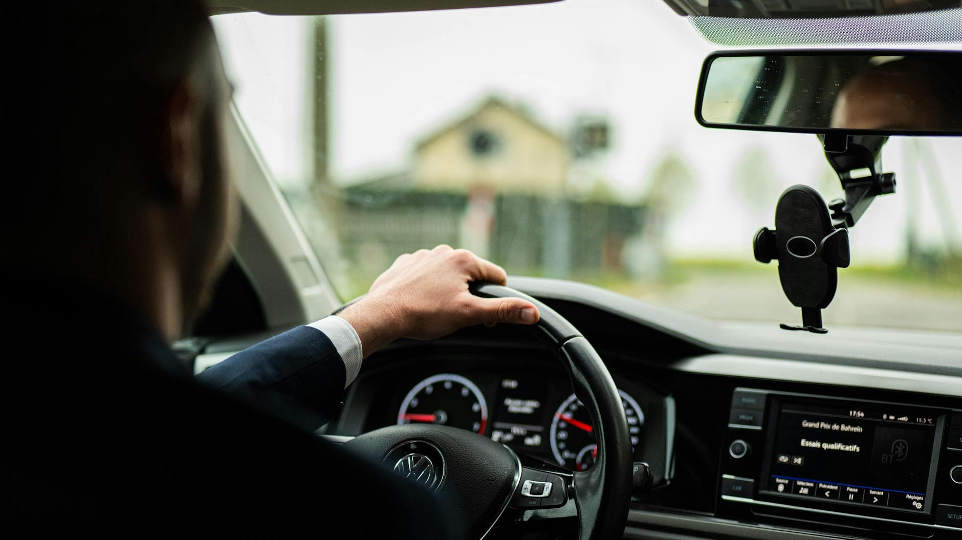Biznesmen w garniturze prowadzi nowoczesne auto, zbliżenie na kokpit