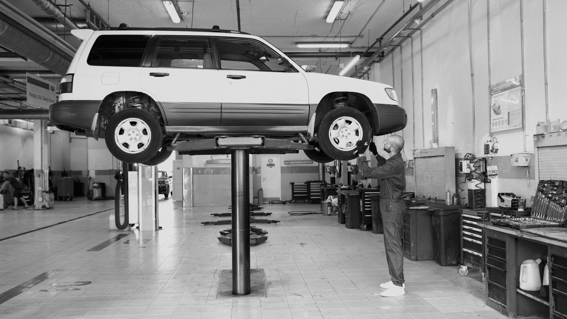 Mechanik sprawdza podniesione auto w dobrze wyposażonym warsztacie