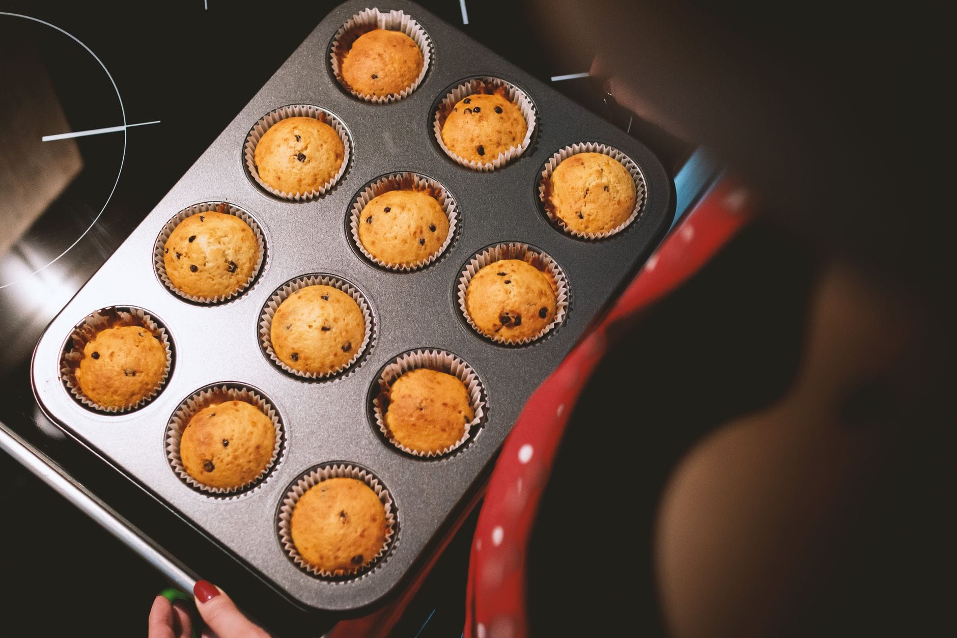 Blacha z świeżo upieczonymi muffinkami z czekoladą wyjęta z piekarnika