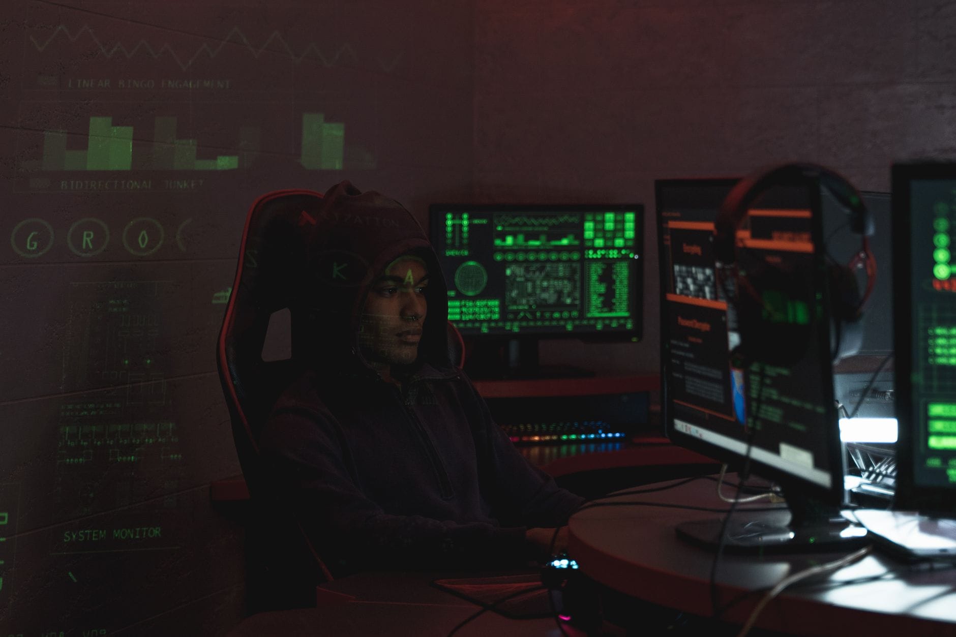 Specjalista w czarnej bluzie analizuje zagrożenia cyberbezpieczeństwa na monitor